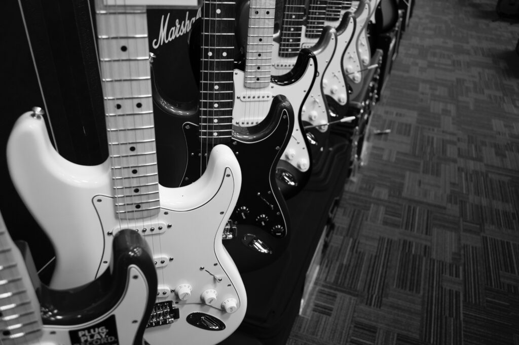 Many guitars standing on guitar stands